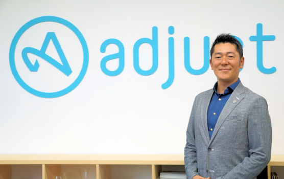 アプリのアトリビューションを基点にテクノロジー適用領域を拡充-統合プラットフォーム化を進めるAdjustの展望 写真:adjust ロゴ前に立つ